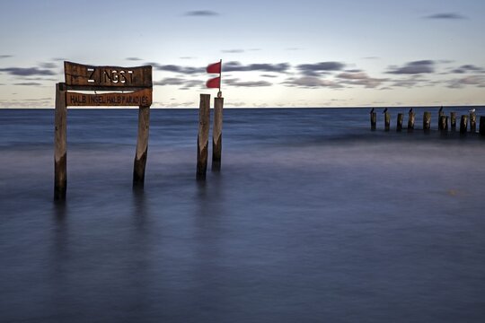 Wooden sign in the sea with inscription Zingst and Buhnen, long exposure, evening light, Zingst, Fischland-Dar&szlig;-Zingst, Western Pomerania National Park, Mecklenburg-Western Pomerania, Germany