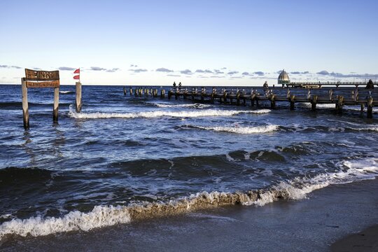 Wooden sign in the sea with inscription Zingst and wooden footbridge, back pier with diving gondola, panorama, evening light, Zingst, Fischland-Dar&szlig;-Zingst, Western Pomerania Lagoon Area National Park, Mecklenburg-Western Pomerania, Germany