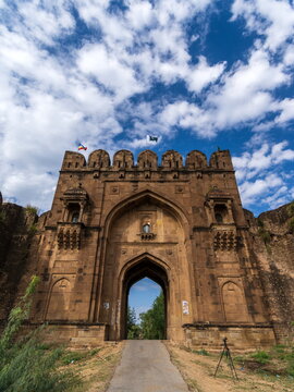 View of the magnificent Rohtas Fort gate, an imposing structure against a backdrop of a blue sky with scattered clouds, Rohtas Fort, Punjab, Pakistan.