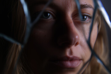 Caucasian female reflected in broken mirror close-up portrait