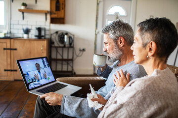 Mature husband and wife concerned during telehealth visit at home