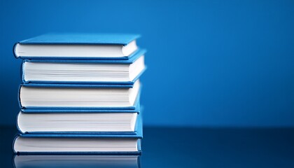 stack of blue books with white pages against a vibrant blue background