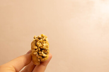 Sweet snack held in hand with a nut topping in a simple setting