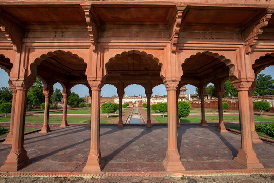 View of the Baradari in the Hazuri Bagh, with its red sandstone arches framing the manicured lawns and distant buildings, Lahore, Punjab, Pakistan.
