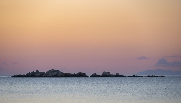 Rocks in the sea at sunset, Aegean Sea, Paros, Cyclades, Greece