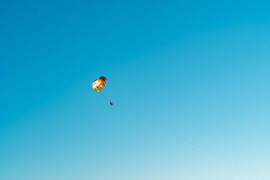 Parasailing adventure against a vibrant blue sky