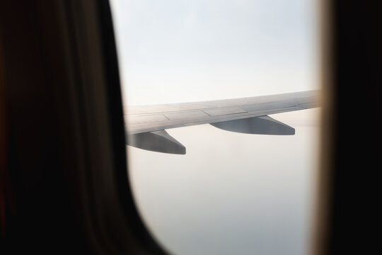 Airplane wing view through window during flight