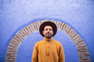 Man in front of blue wall in Chefchaouen, Morocco