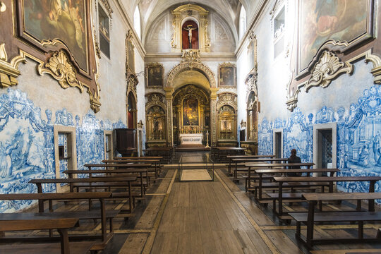 View of intricate blue and white tilework contrasting with the warm wood benches and golden altar in a historic church, Lisbon, Lisbon, Portugal.