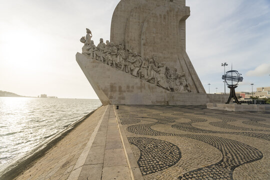 View of the stark white Padr&Atilde;&pound;o dos Descobrimentos juts into the Tagus River on patterned cobblestones under a vast sky, Lisbon, Lisbon, Portugal.