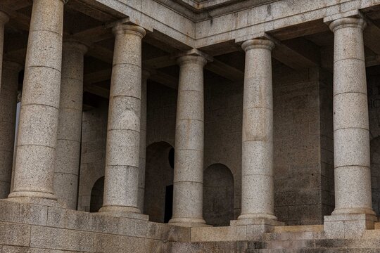 View of stone columns standing in silent formation, their textured surfaces catching the light in a rhythmic pattern, Rhodes Avenue, Cape Town, Western Cape, South Africa.