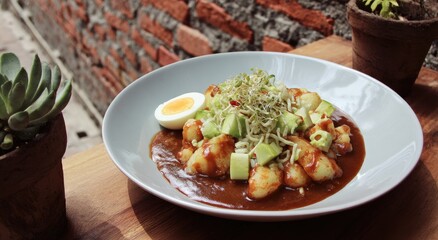 Plate of savory dish with potatoes, egg, and sauce