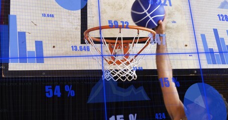 Reaching basketball player holding blue ball above rim in gym, in sleeveless top with data overlays