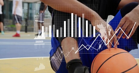 Crouching athlete holding orange basketball at painted court in black top blue shorts with charts