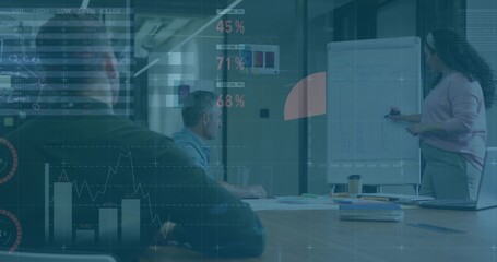 Presenting woman wearing pink top marking whiteboard in meeting room, with data charts, copy space