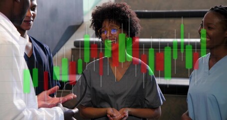 Gesturing doctor in lab coat, team in scrubs with stethoscope talking near clinic stairs, chart