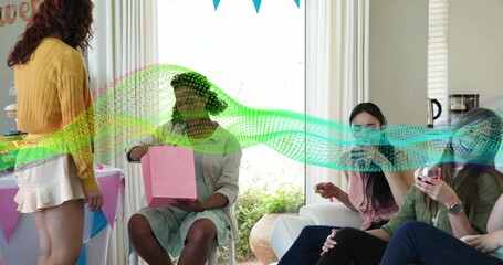 Looking into pink gift bag, woman wearing pale green dress and headband at home living room