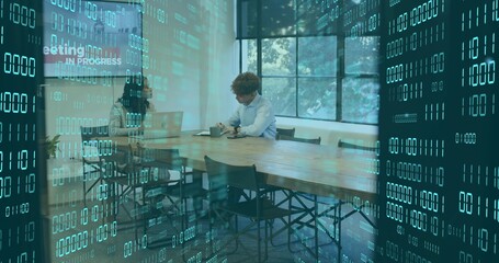 Discussing two coworkers in office attire reviewing laptop in conference room, with data overlay