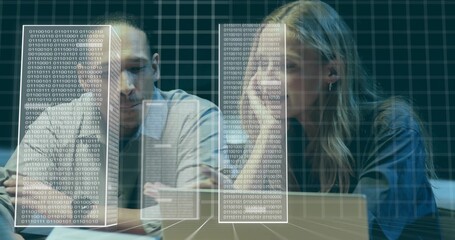 Reviewing coworkers in light shirt and dark jacket at dim lab, viewing laptop, holo binary grid