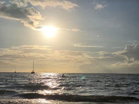 The Sun Over the Ocean in the Evening with a Kayaker in the Background