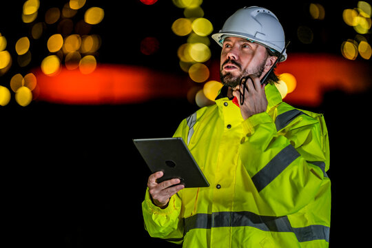 Safety officer inspecting industrial risk data. Emergency response team leader in high-vis gear reporting accident situation via radio onsite.