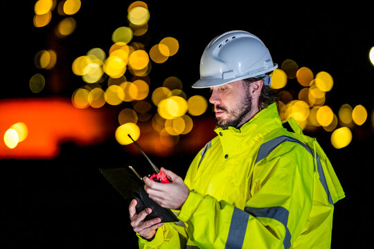 Safety officer inspecting industrial risk data. Emergency response team leader in high-vis gear reporting accident situation via radio onsite.
