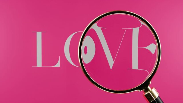 magnifying glass hovering over tex saying love. Valentines, romance, searching for love