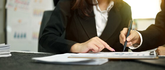 Business consulting. People discussing the charts and graphs showing the results of their successful teamwork