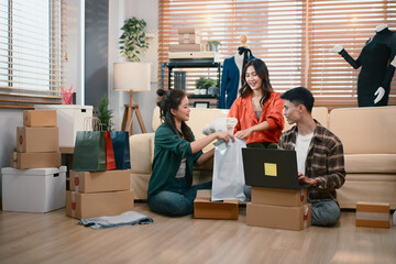 SME team discussing packaging and tracking customer orders at home office, reviewing parcels and logistics workflow together