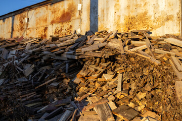 Wood pile stacked against an old wall during the late afternoon light near a construction site