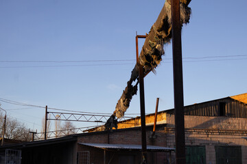 Old industrial site with damaged pipeline and clear sky during late afternoon