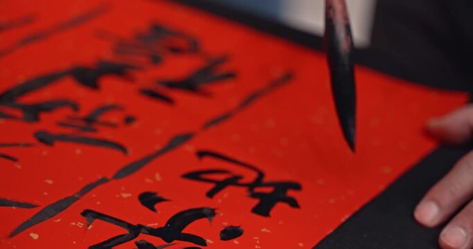 Writing Chinese calligraphy with phrase meaning may you have a prosperous New Year