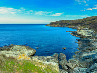 Coastline view near the water with rocks and shoreline during the day in a clear sky without clouds