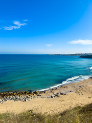 Coastal view with clear blue water and sandy beach during daytime in a natural setting