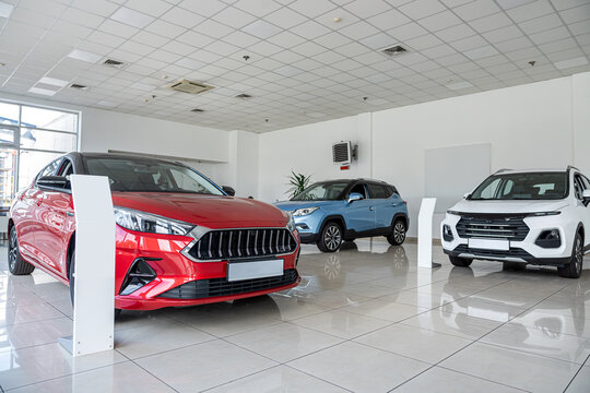 New luxury red car in modern showroom. Automobile sale or rental concept