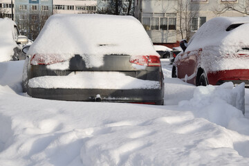 Winter landscape. Cars are parked in a snow-covered lot.
