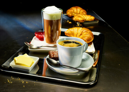 Fr&uuml;hst&uuml;ckstablett mit Kaffesorten und Croissant mit Butter