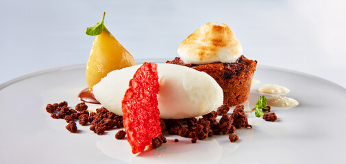 Holundertörtchen mit Birne und Nocke auf weisser Porzellanplatte