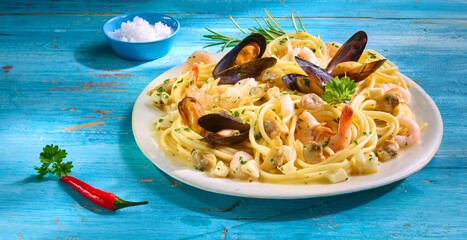 Spaghetti mit Miesmuscheln und Schale mit Salz auf hellem Teller