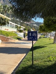 Traffic sign indicating pedestrian and vehicle path on sunny street background
