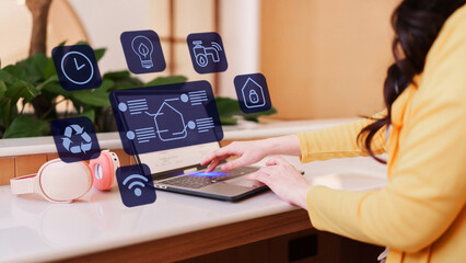 User manages smart home system on laptop for energy efficiency resource conservation and security automation to control consumption smart home energy efficiency iot