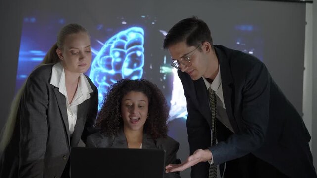 Students discuss technology concepts in a classroom setting with a projection in the background