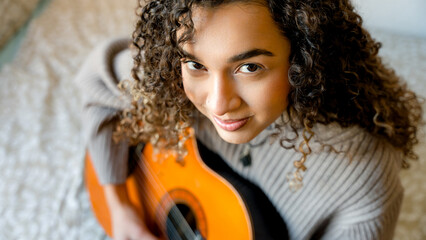 Young woman enjoying music with the guitar