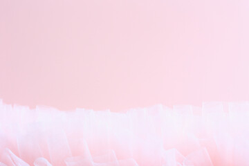 Soft pink background with copy space and delicate pink fabric