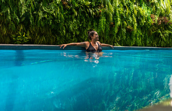 Woman enjoying a swim indoors with green backdrop