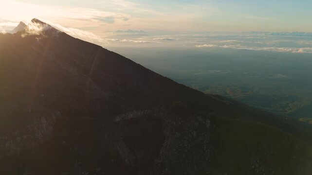 4K drone footage of Mount Raung at sunrise, revealing steep ridges, misty forests, and one of Indonesia&rsquo;s most extreme hiking trails with cloud and vulcano 