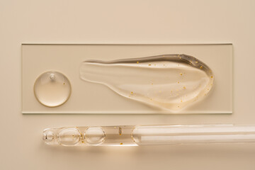 Cosmetic gel texture with golden specks and glass pipette