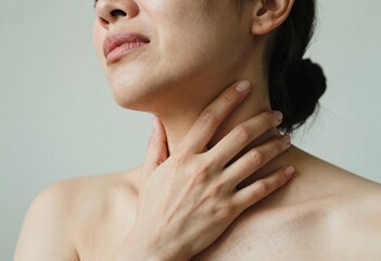 A woman experiencing neck pain, holding and pressing her neck with a strained expression, showing discomfort and tension