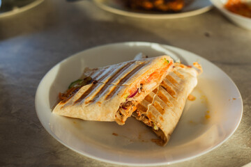  preparing homemade wrap with fresh vegetables and meat on kitchen table. Healthy cooking, street food and home food preparation concept.