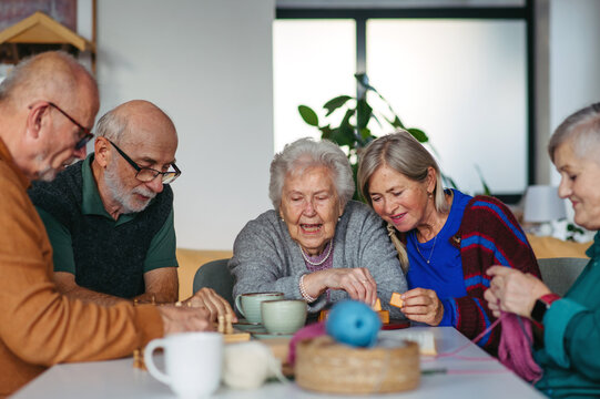 Group of senior people enjoying different activities in community center.